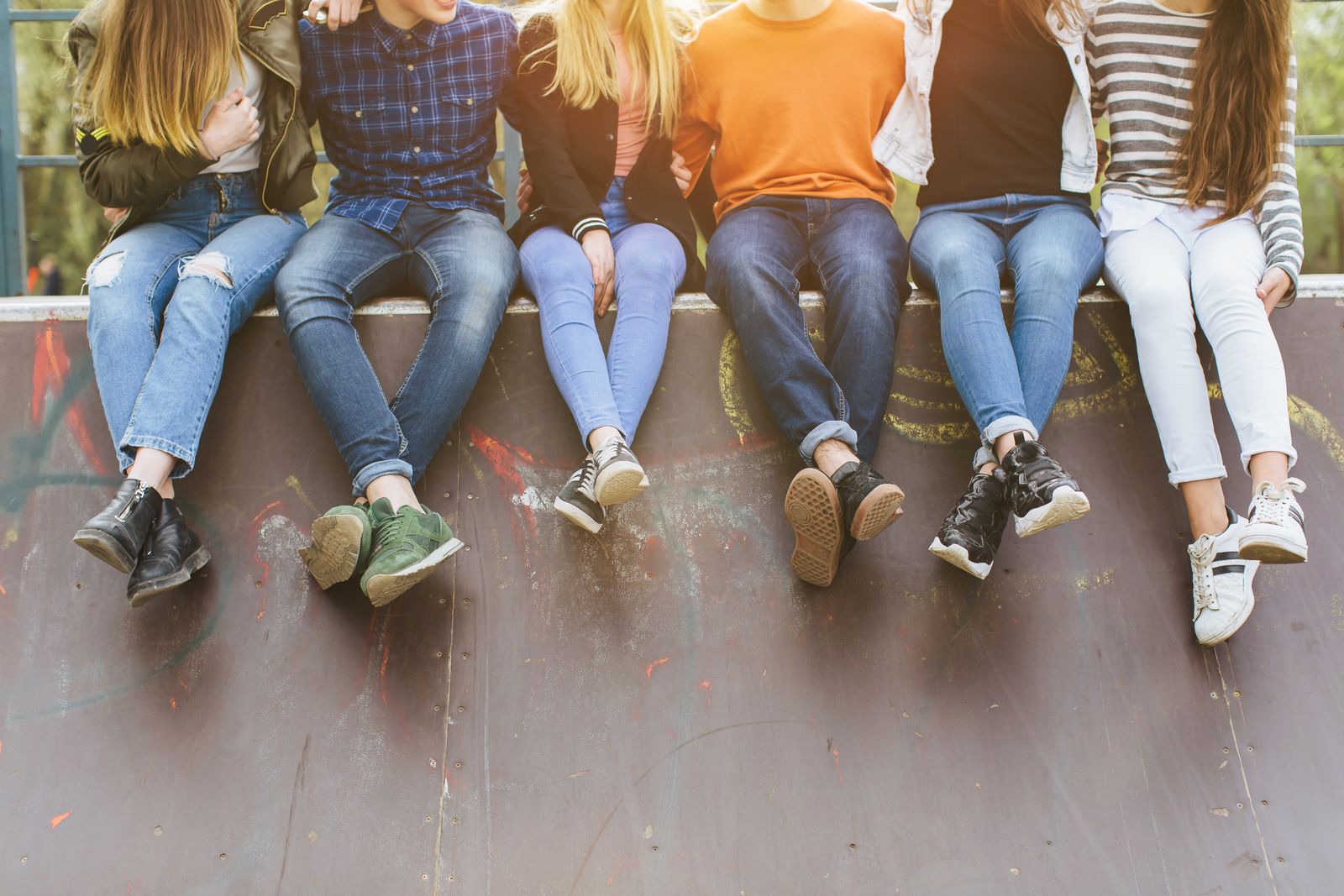A group of teens hanging out together on a skate ramp